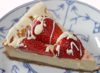 ein Stck Ksekuchen mit Erdbeeren und weier Schokolade